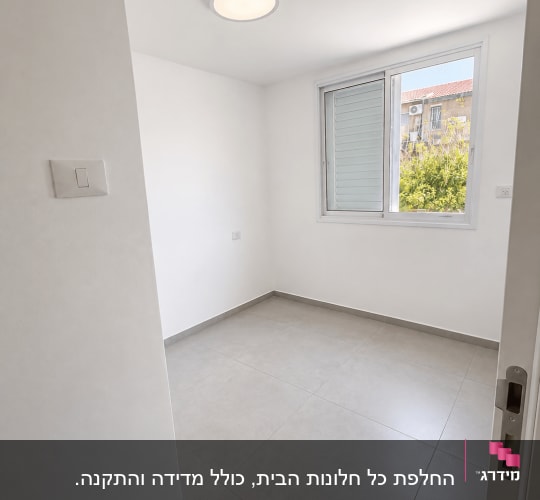 חלון אלומיניום לבן מותקן בחדר מגורים מוארת ונקייה